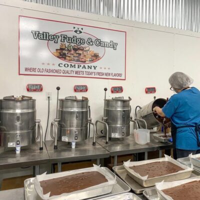 Valley Fudge and Candy employee pouring chocolate fudge into baking tray.
