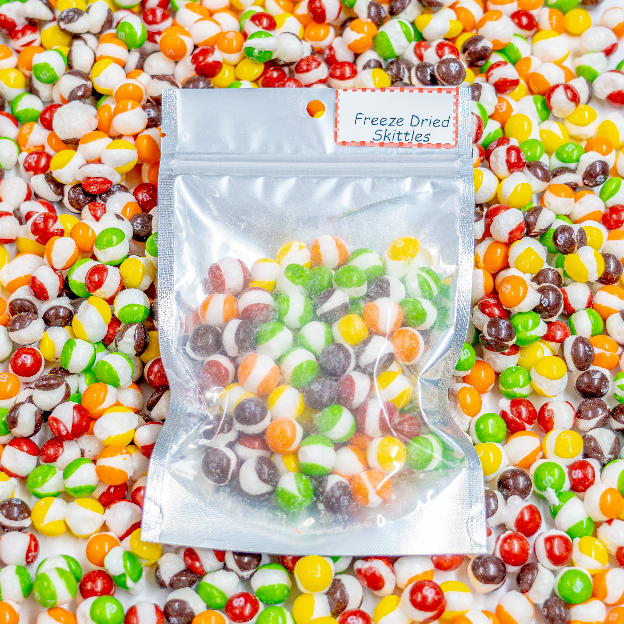 2.5 ounce bag of freeze dried skittles on top of assortment of freeze dried skittles
